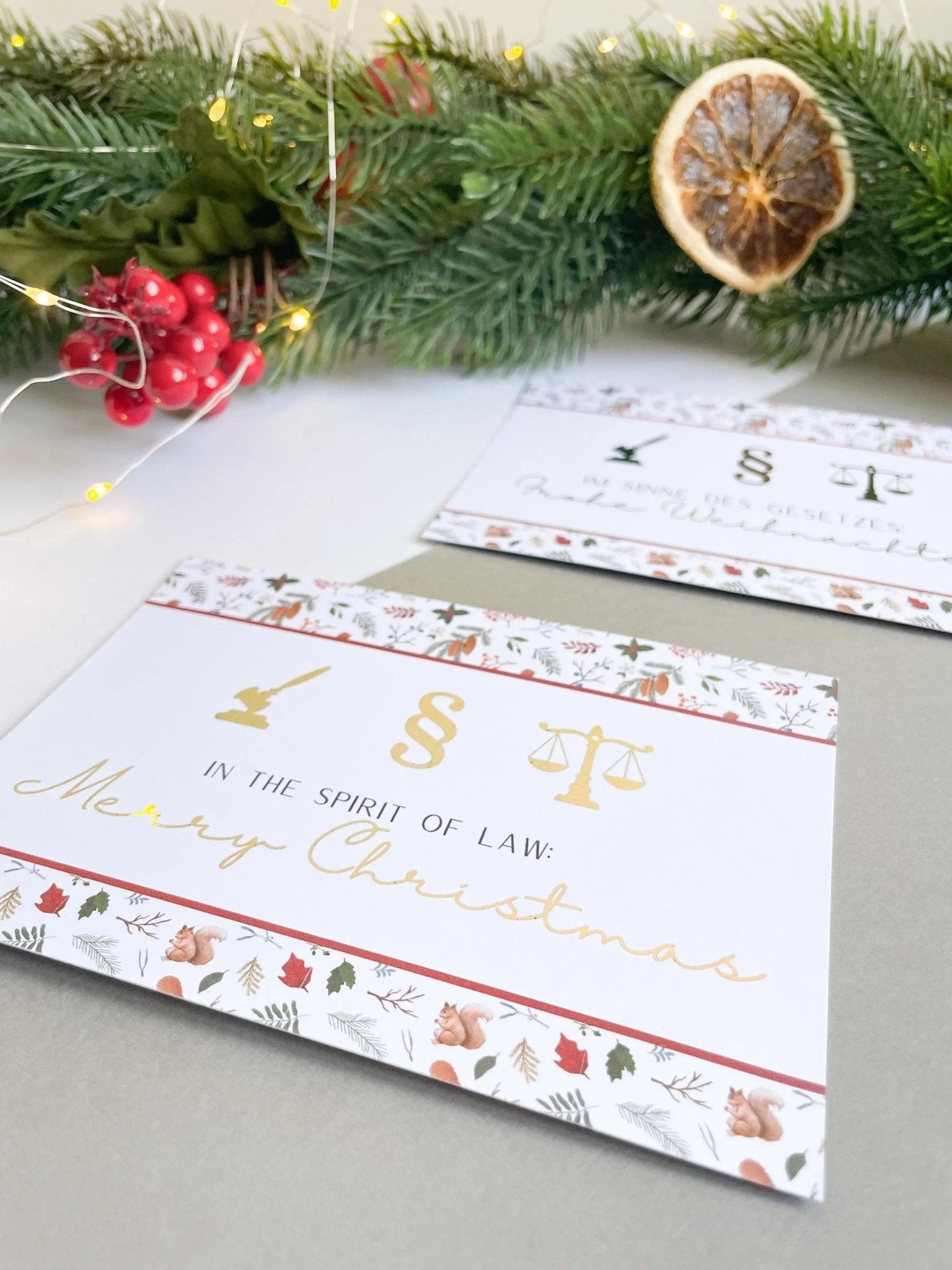 Jura Weihnachtspostkarten mit Waage, Paragraph und Richterhammer vor einem grünen Tannenzweig