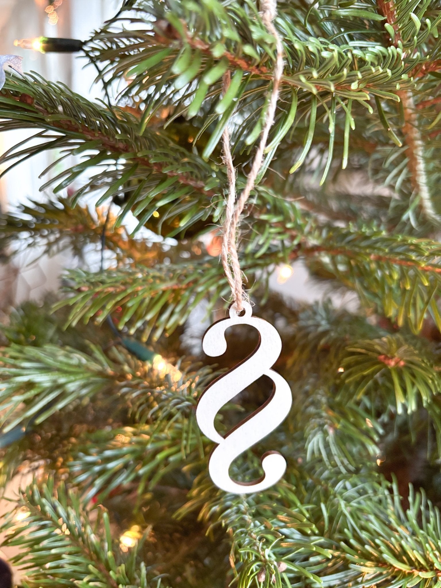 Christbaumanhänger Paragraph aus Holz an einem Tannenbaum hängend.